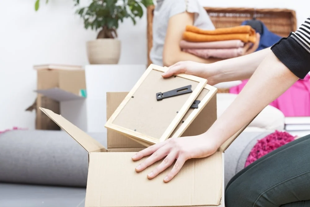 Close up of woman's hand packing two photo frames-1